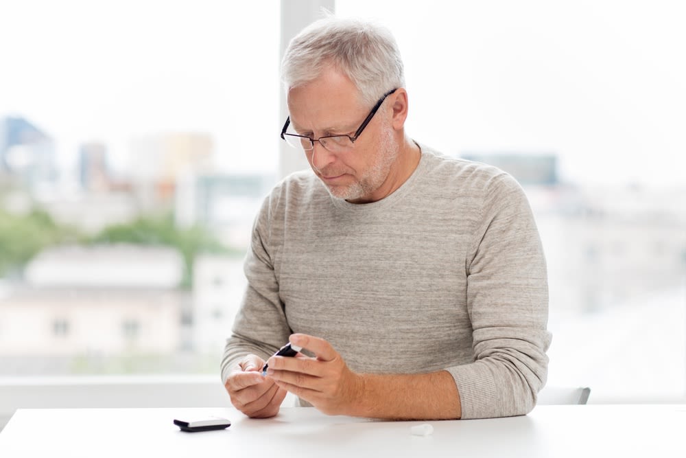Man with diabetes testing his blood glucose levels